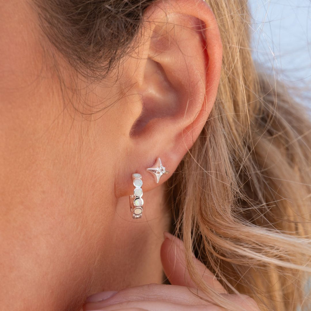 Ear that wears Opalite Lagoon Hoops and white topaz true north studs 